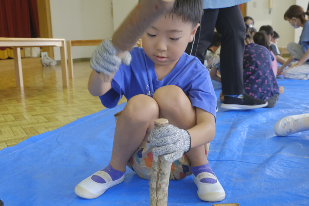 ナイフで入れた切込みに、くさびを打ち込むと、枝がピシ、ピシ・・！