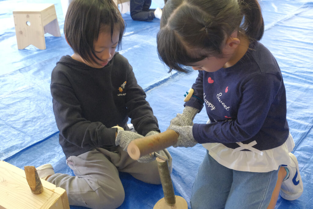 先生が作ったマレットで木の枝を割ります