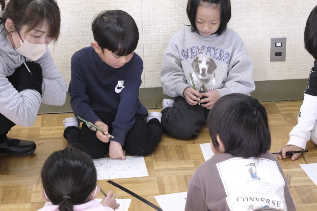 鉛筆で絵を描く子ども達